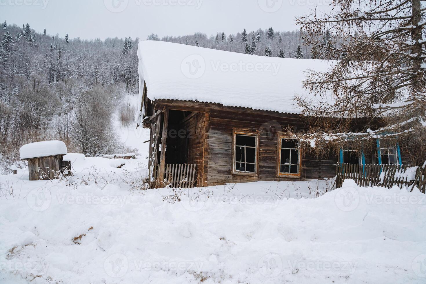 A picturesque log cabin, blanketed in a thick layer of snow, nestled in the heart of a serene, snowy forest, creating a cozy winter retreat surrounded by natures beauty photo