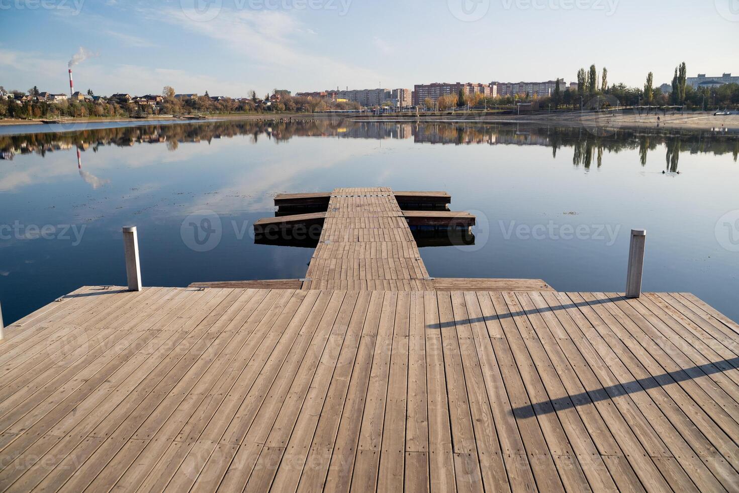 A beautifully crafted wooden dock gracefully extends into the crystalclear water, creating a serene and picturesque scene that truly embodies the essence of nature and harmony all around photo