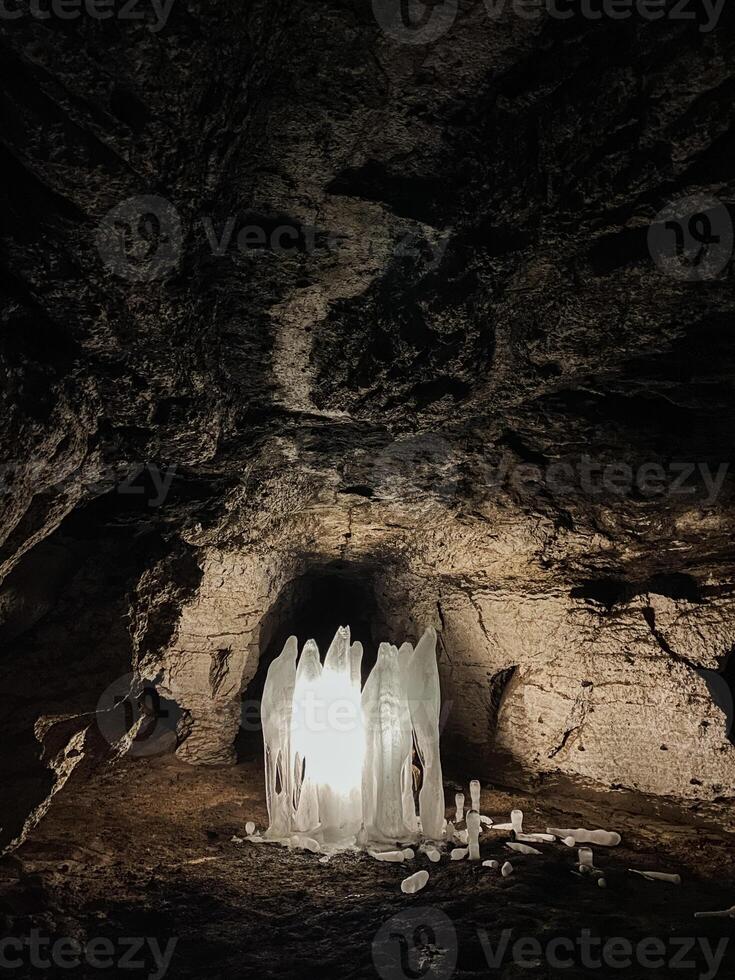 Deep within the earth lies a fascinating cave, where a bright light shines brilliantly at its center, illuminating the dark surroundings and creating an enchanting, mystical atmosphere photo