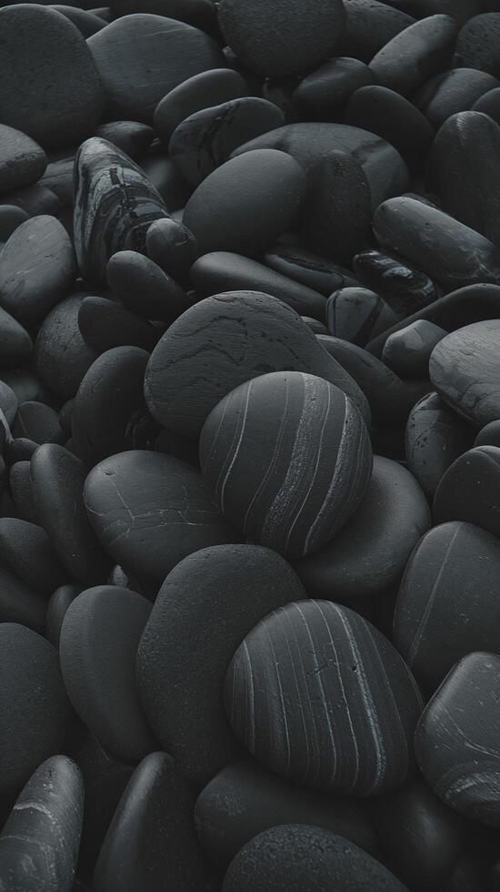 Closeup of Smooth Black River Stones with Natural White Patterns and Texture in a Dark Background photo