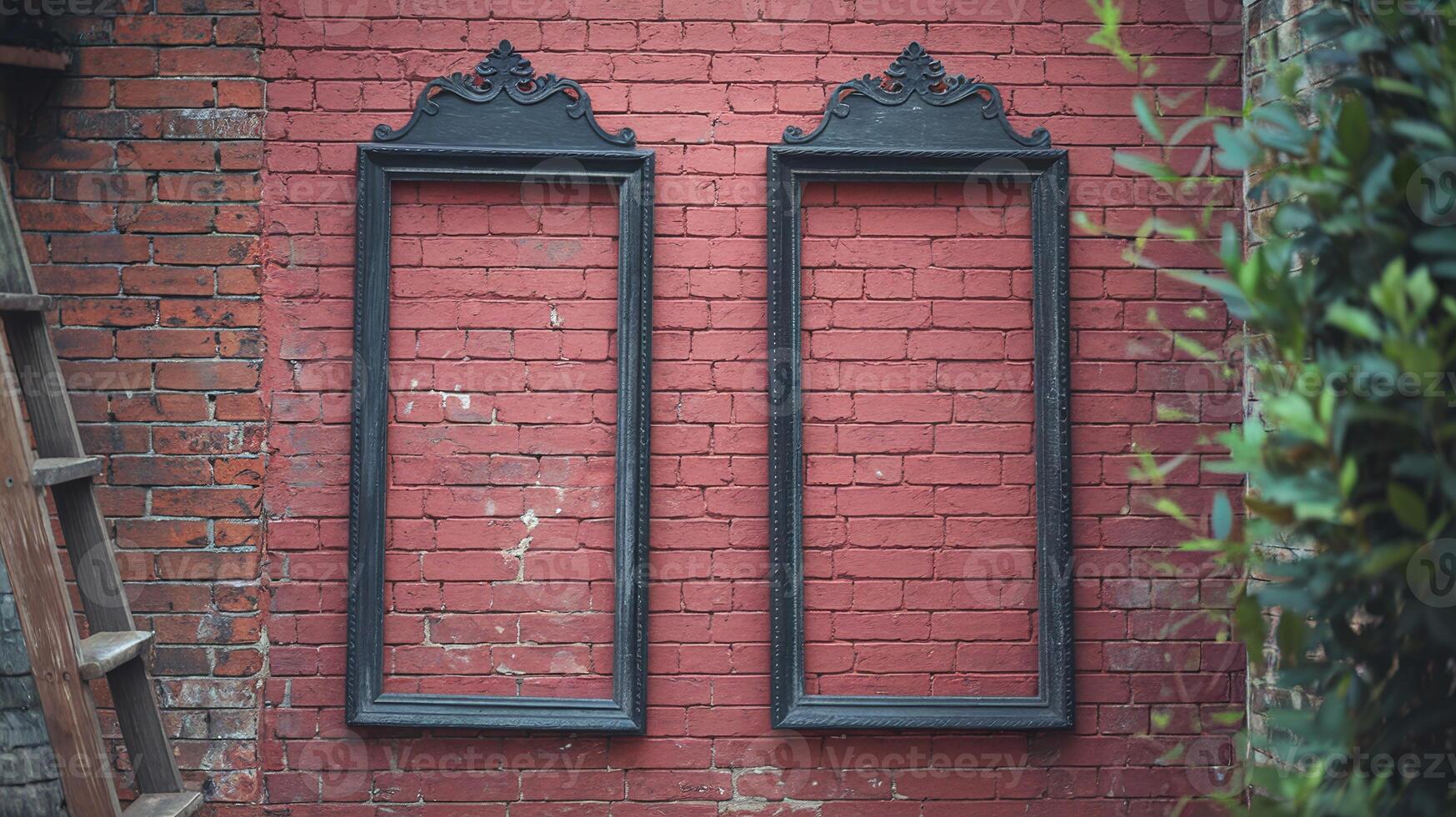 Two Empty Ornate Black Vintage Frames On Textured Red Brick Wall With Green Foliage And Wooden Ladder photo