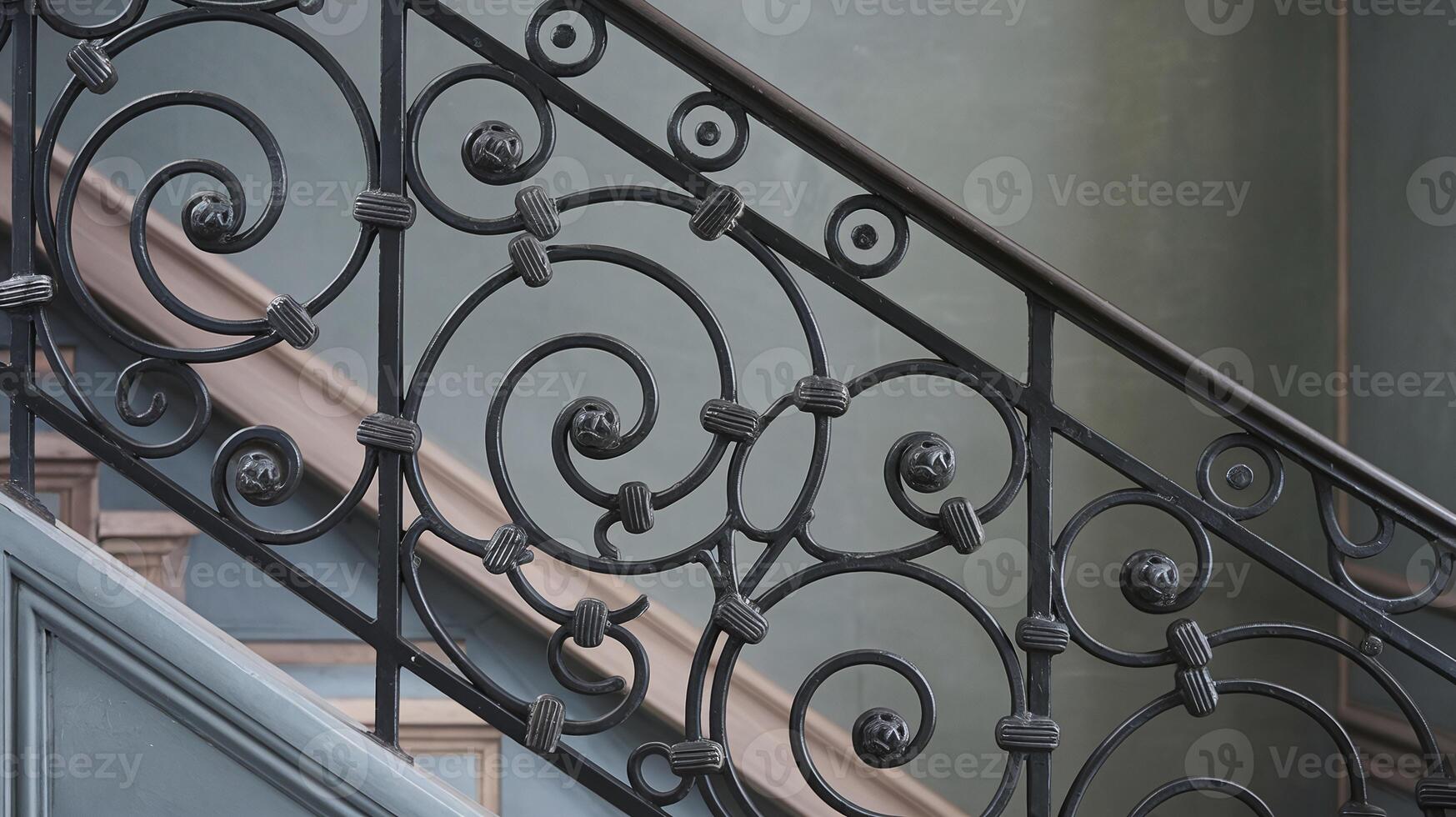 Elegant Black Wrought Iron Staircase Railing with Intricate Scrollwork on Gray Wall Background photo