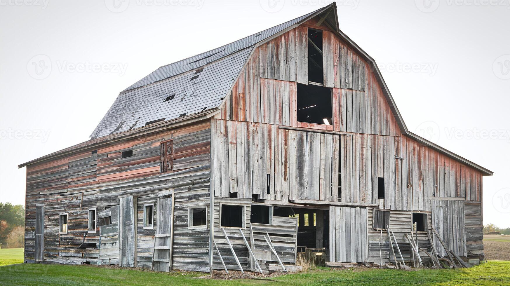 Old Weathered Wooden Barn on Green Grass Field with Rustic Texture and Open Windows in Countryside photo