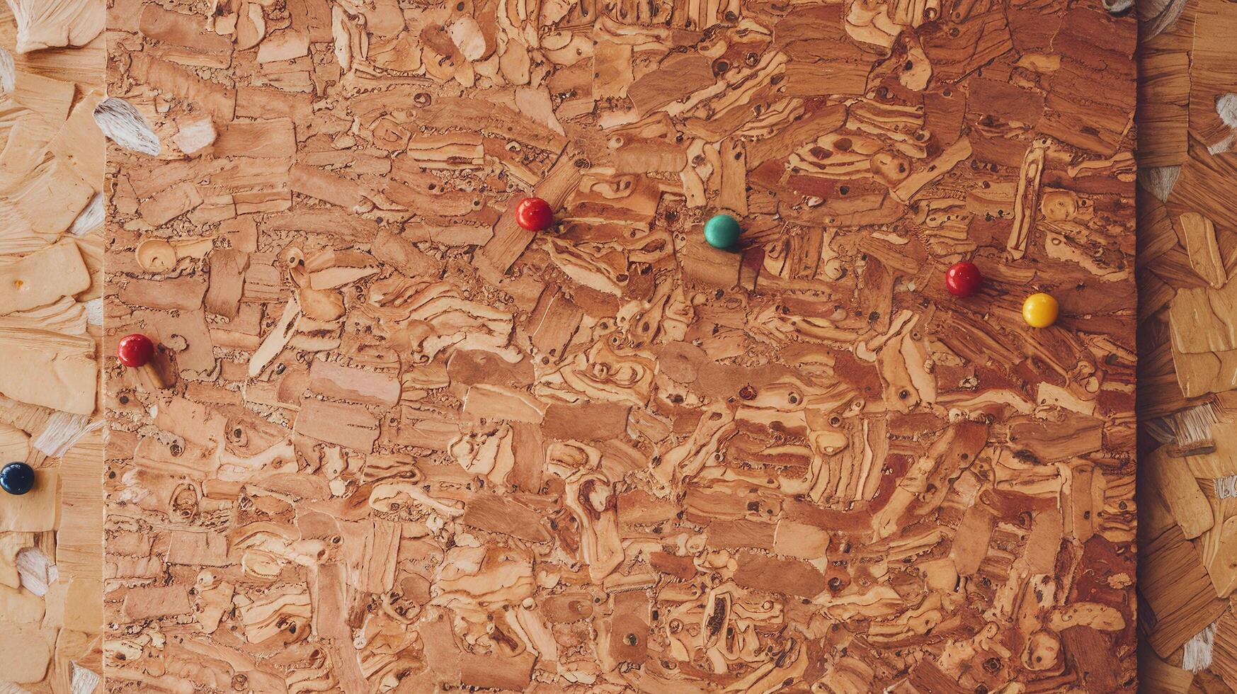 Natural Cork Board with Colorful Push Pins on Wooden Background for Organization or Office Decor photo
