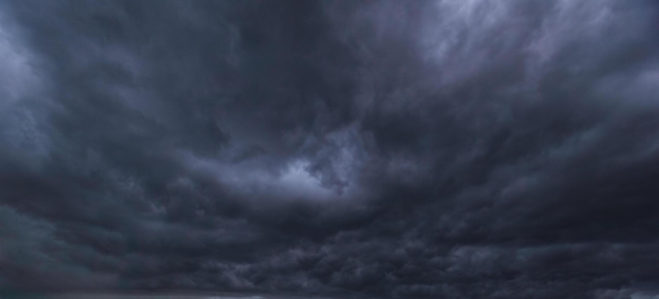Bad or moody weather sky and environment. carbon dioxide emissions, greenhouse effect, global warming, climate change. The dark sky with heavy clouds converging and a violent storm before the rain. photo