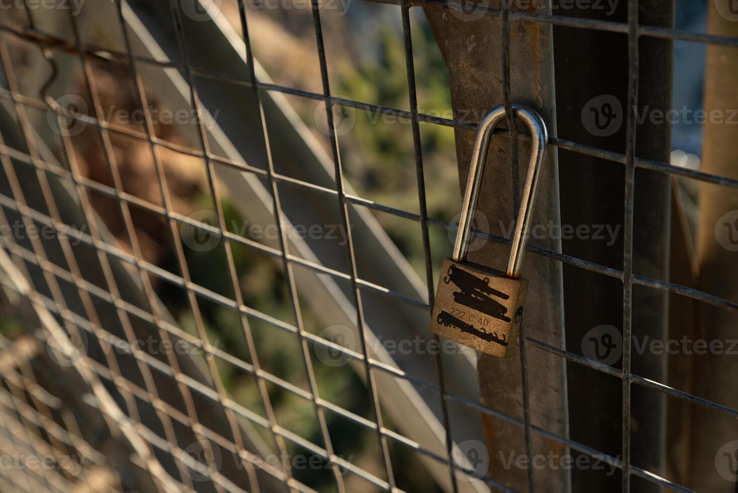 Padlock closed to a fence with names crossed out. photo