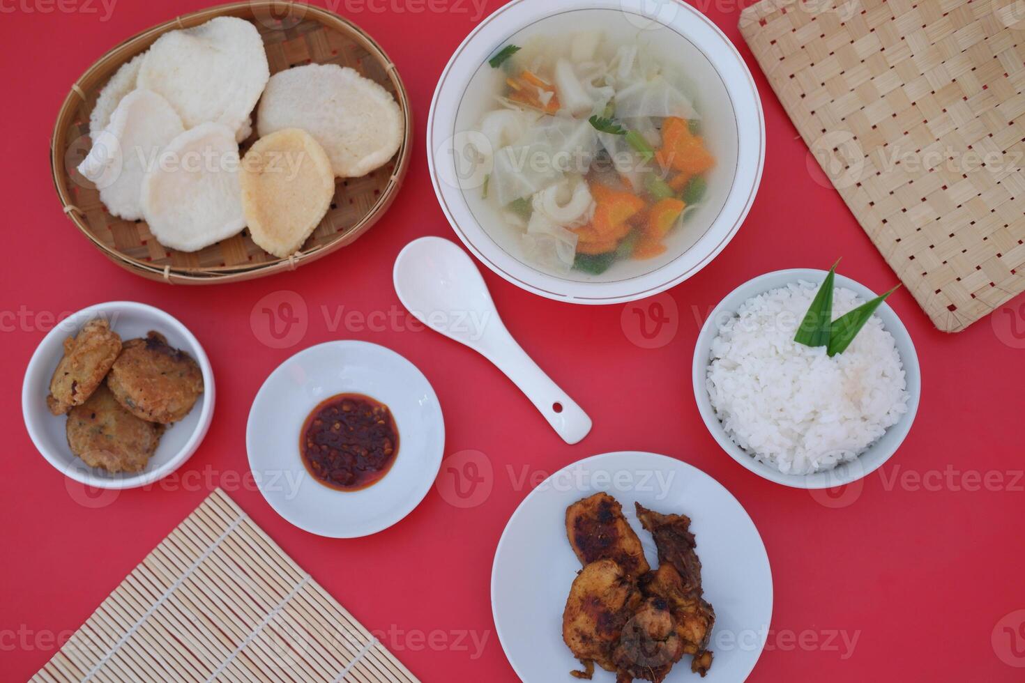 traditional Indonesian food arranged neatly on a red table photo