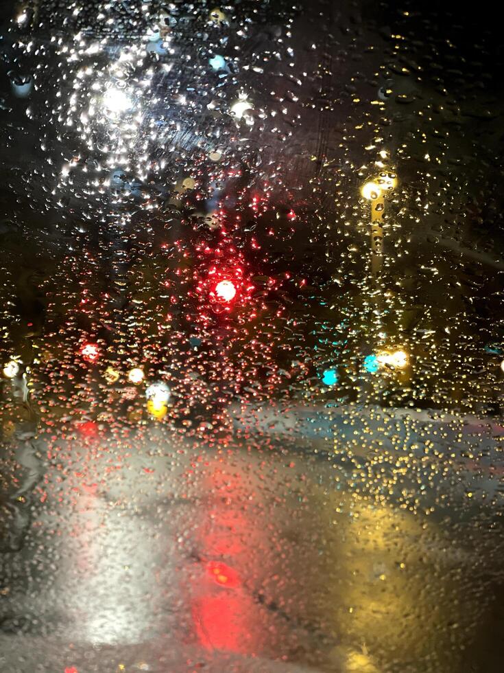Vertical defocused street light and traffic lights with raindrop textured background photo