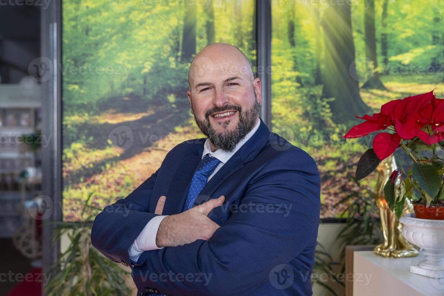 portrait of elegant businessman with beard looking at camera smiling during break in office photo