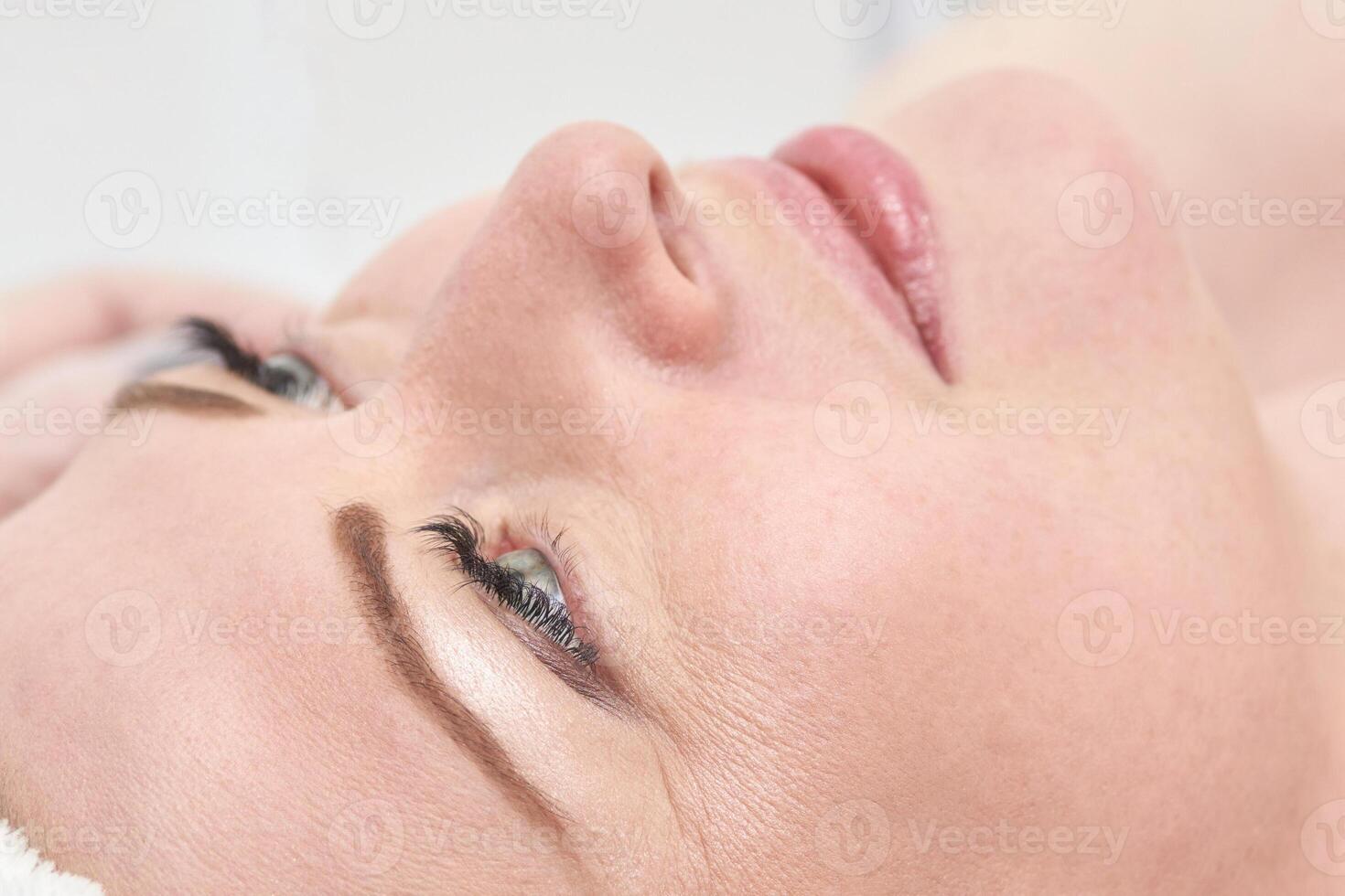 Close up of mature caucasian female relaxing with soft skin and peaceful expression. photo