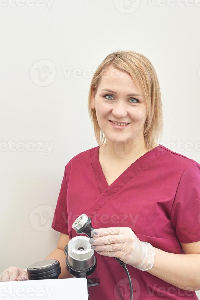 Female caucasian adult smiling in medical uniform holding equipment in healthcare setting. photo