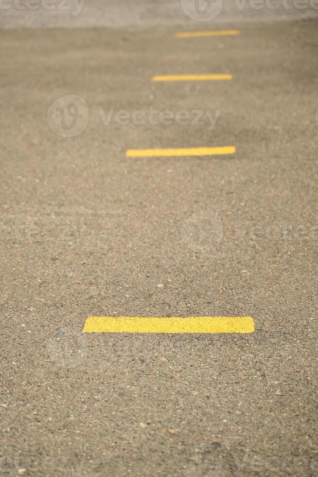 Close up view of yellow road lines on asphalt pavement for traffic safety and directional guidance. photo
