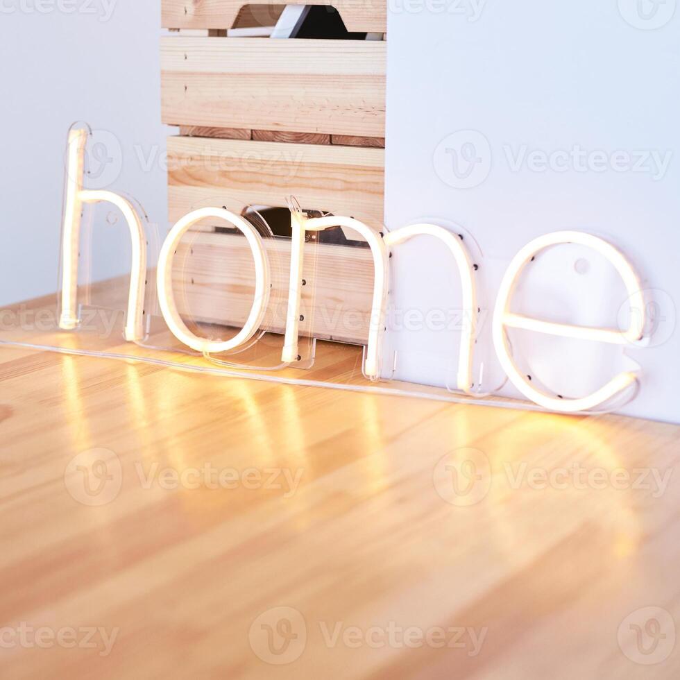 Illuminated neon home sign on a wooden surface with a cozy, minimalist interior design theme. photo