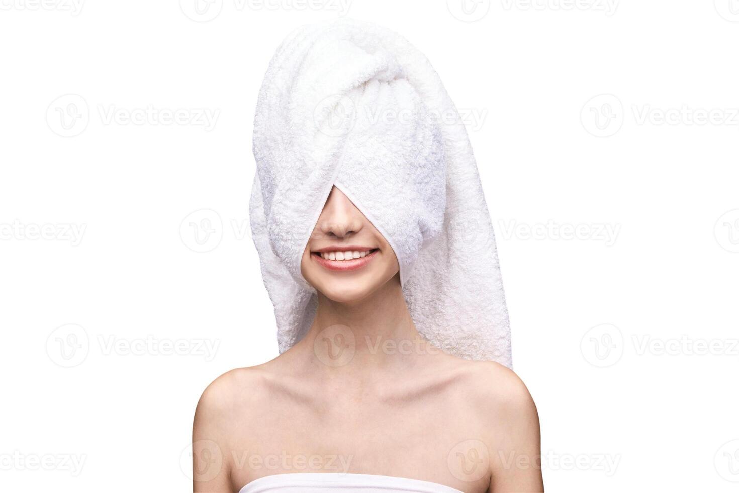 Young caucasian female with towel wrapped around head smiling, white background. photo