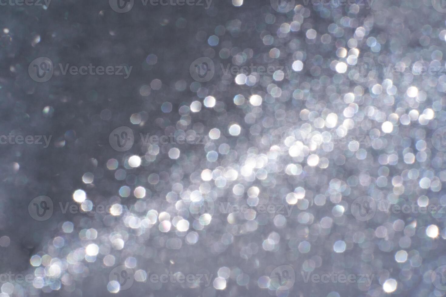 Abstract silver bokeh light pattern with circular glittering effect on dark background. photo