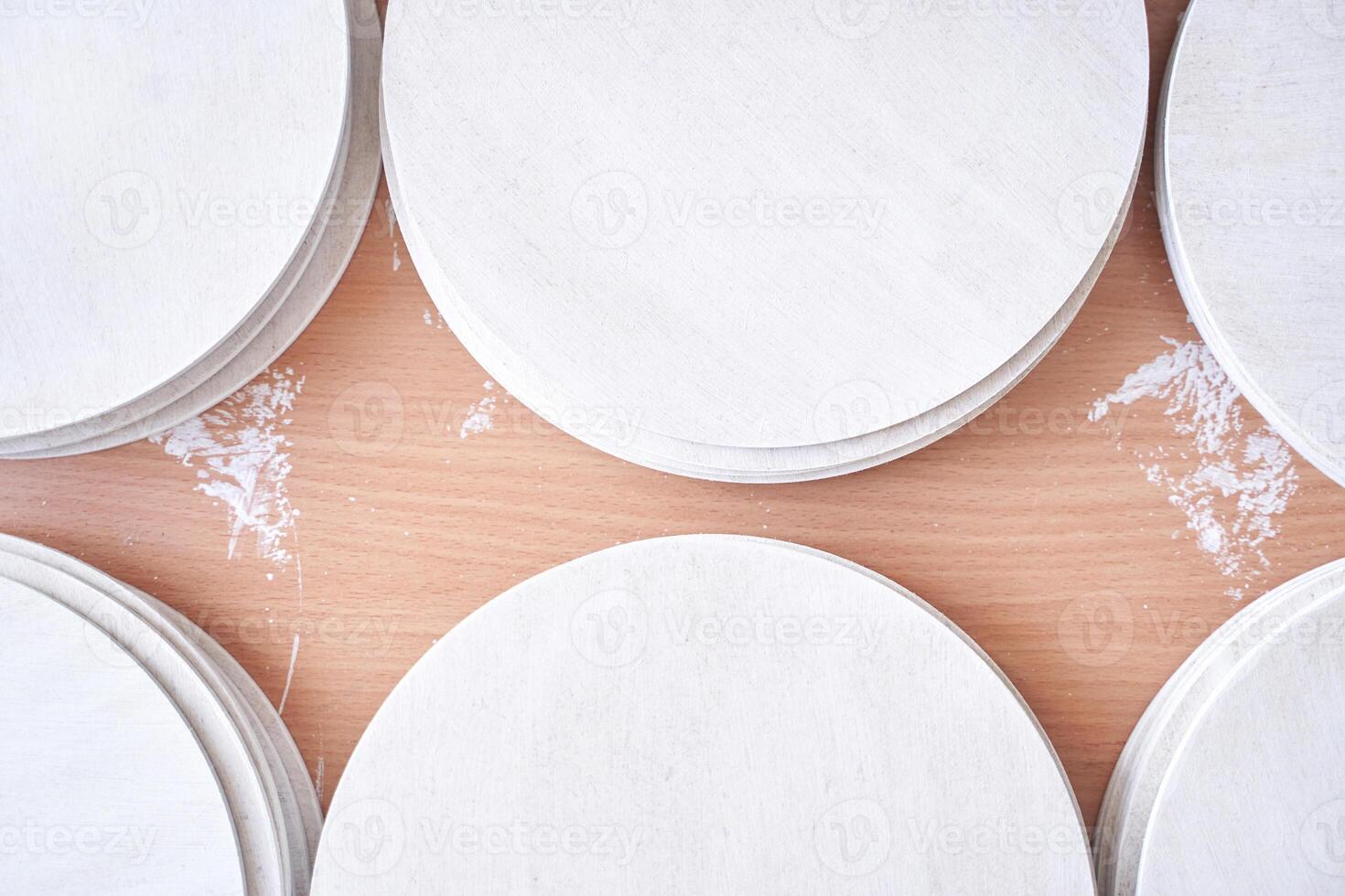Top view of round wooden pizza boards on floured wooden surface for baking. photo
