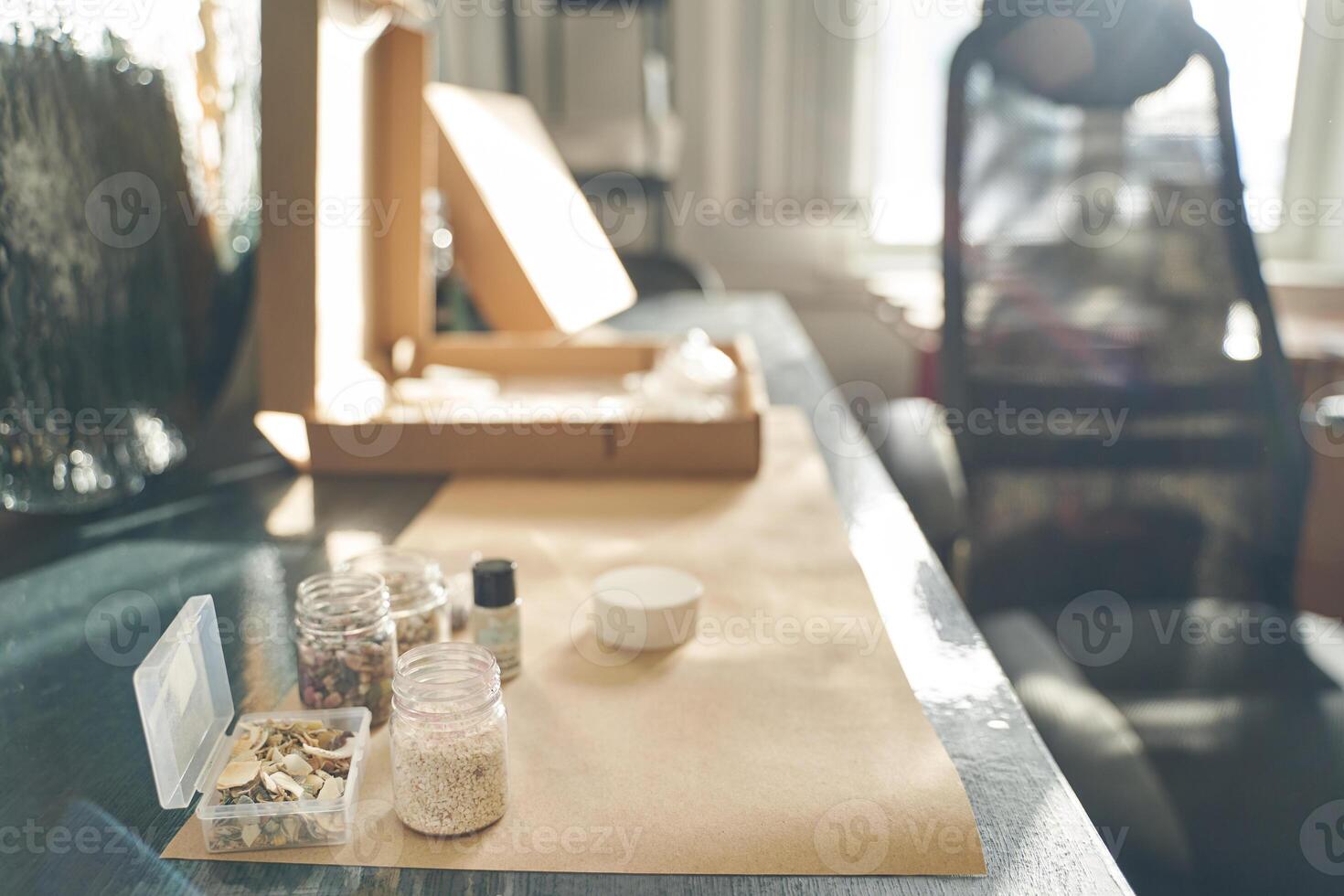 Crafting workspace with open cardboard boxes and assorted art supplies on a sunlit table. photo