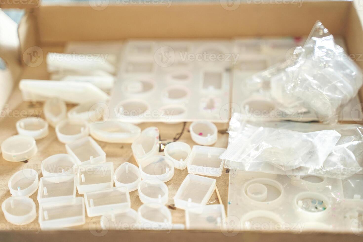 Variety of clear silicone molds for diy crafting projects in cardboard box. photo