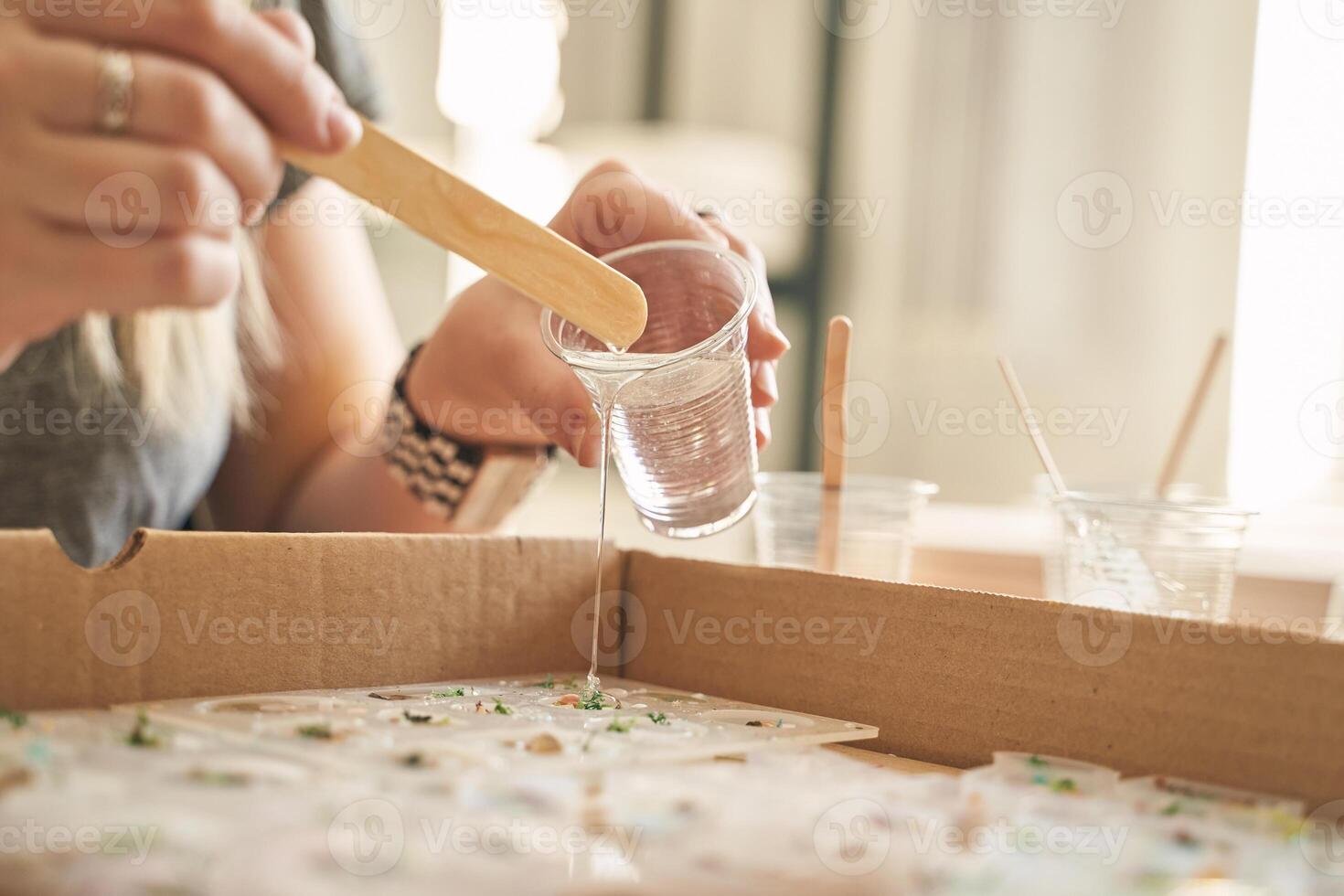 Female adult crafting with resin in creative workshop setting. photo