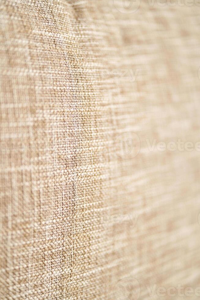 Textured beige fabric close up showing detailed weave pattern and natural material surface. photo