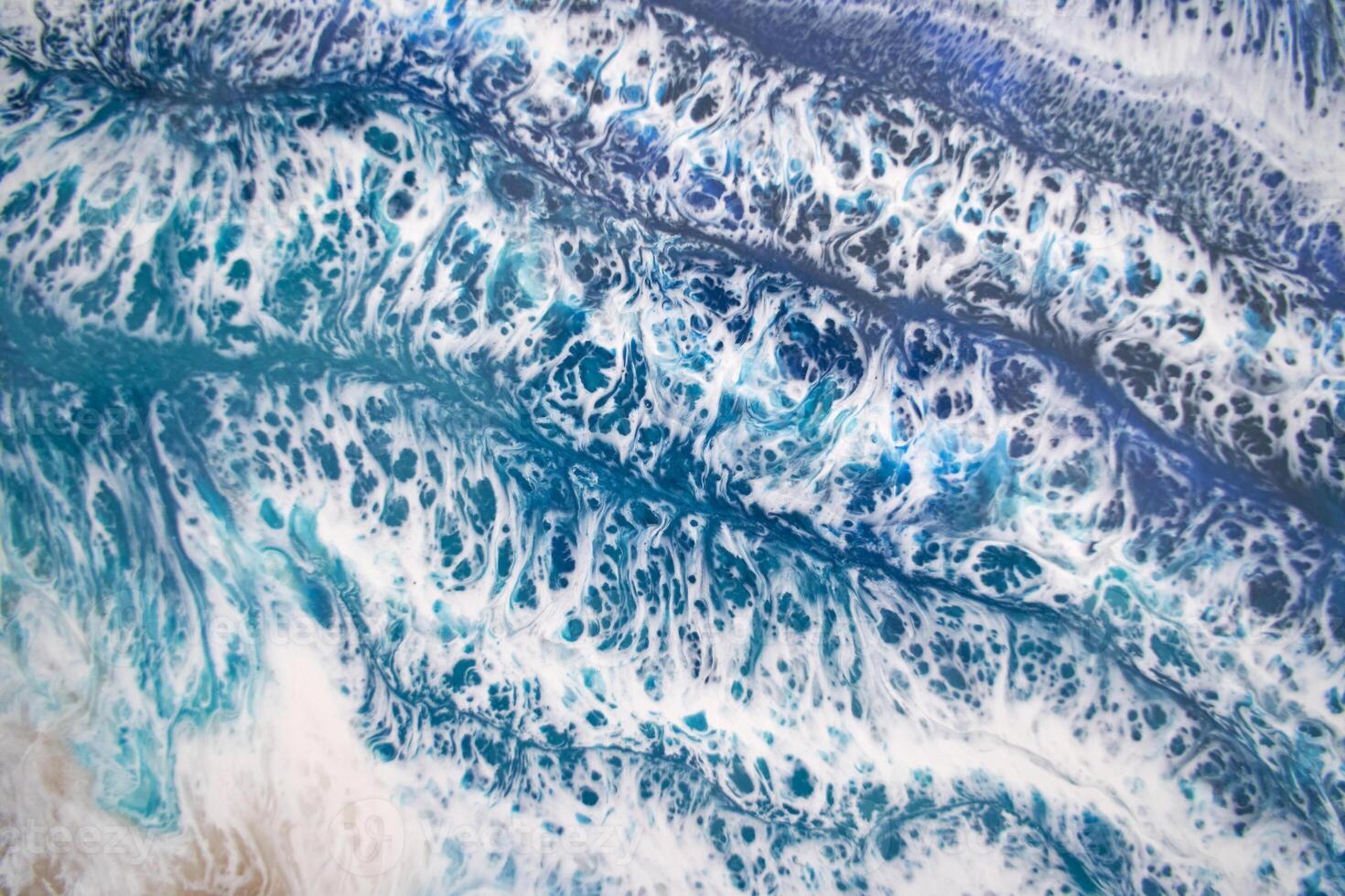 Dynamic ocean wave patterns with foamy blue and white textures show natural coastal beauty. photo