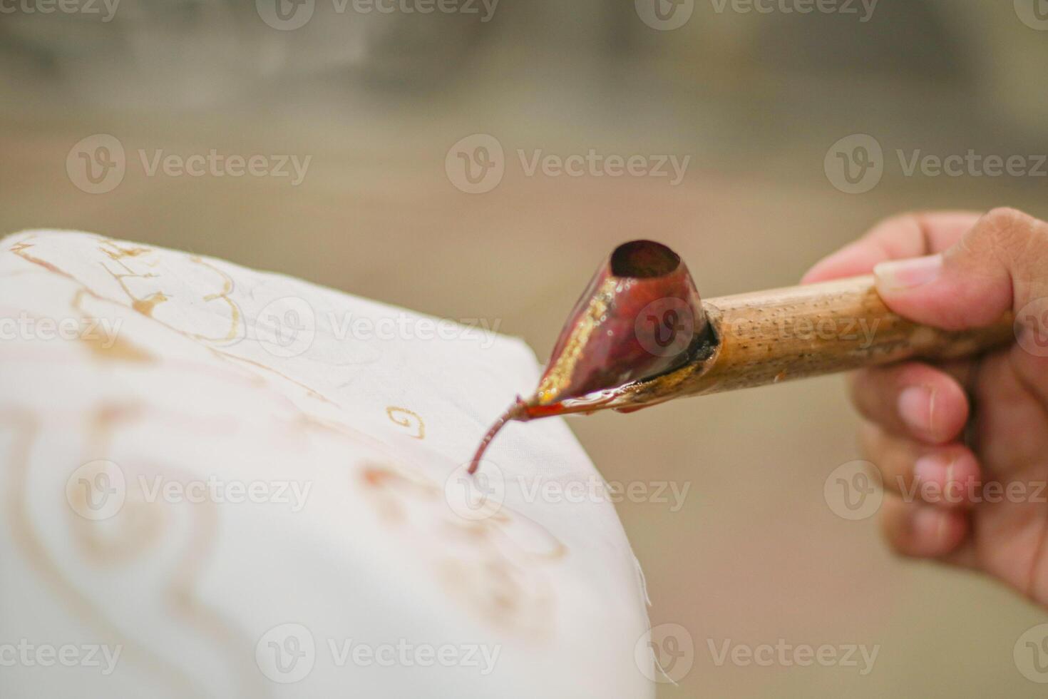 close up of hand hold canting is tool for make batik with isolated white background. Canting batik is tools to make batik. canting batik is used to put wax. canting consists of three type. photo