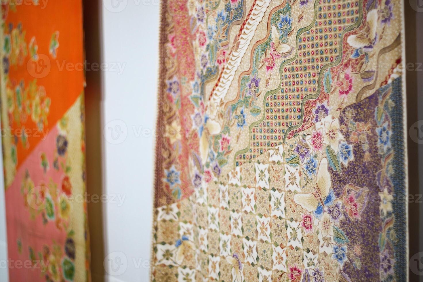 This image displays four vibrant traditional batik textils in an exhibition, showcasing the intricate craftsmanship of indonesia artisans. photo