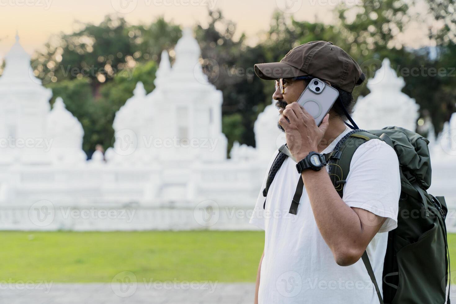 Caucasian gray-haired man tourist having remote conversation communicate speaking by smartphone with friend. photo
