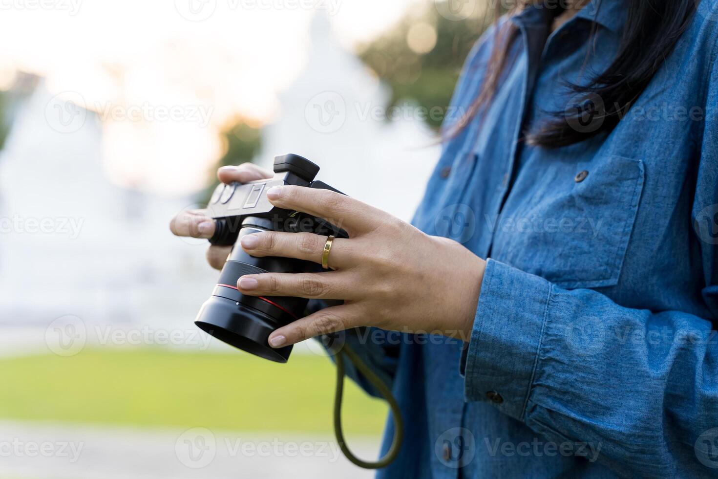 Senior woman using camera and looking at photos in nature. Finger pointing on camera display.