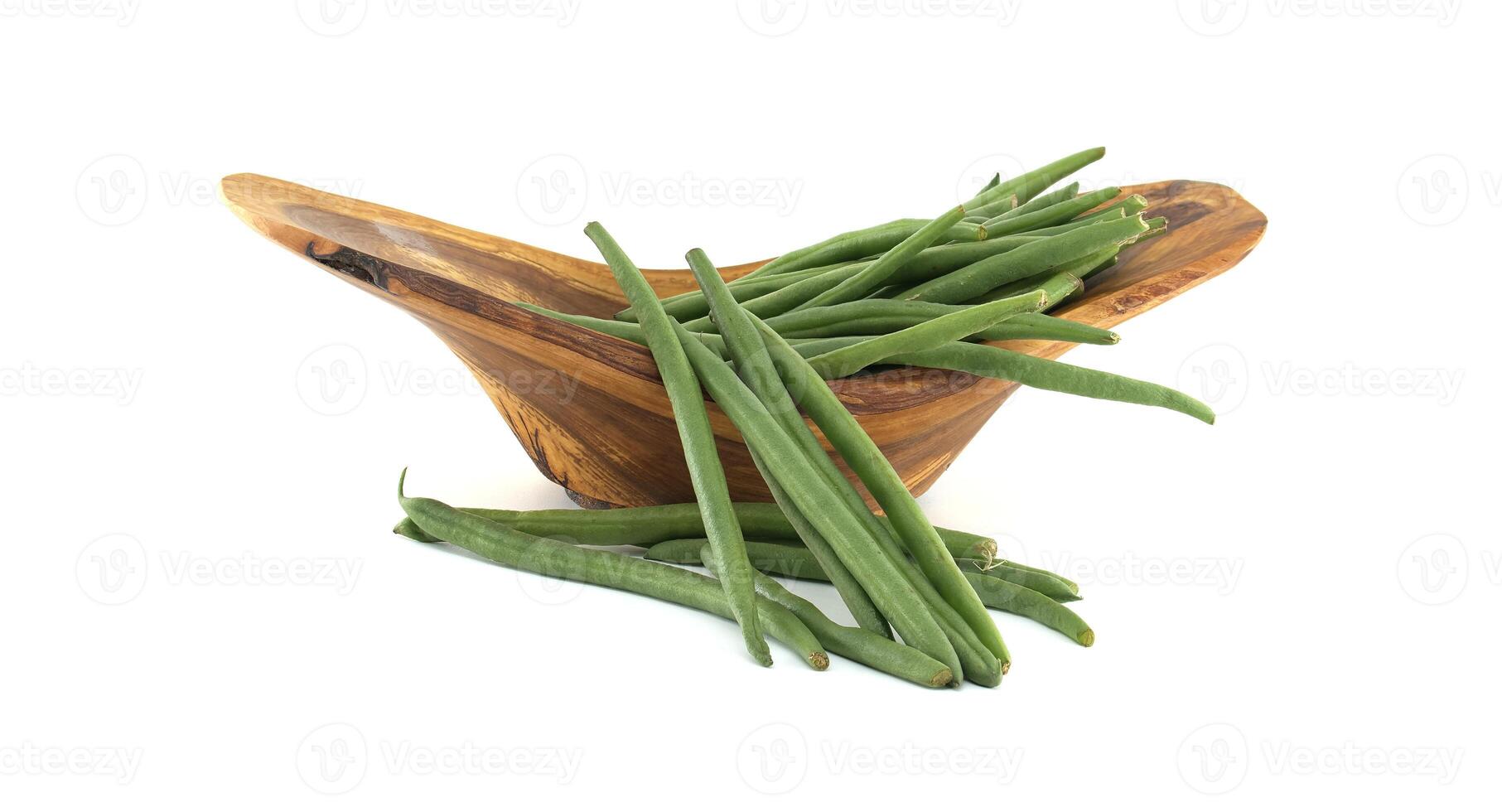 Fresh green beans overflowing a wooden bowl on white background photo