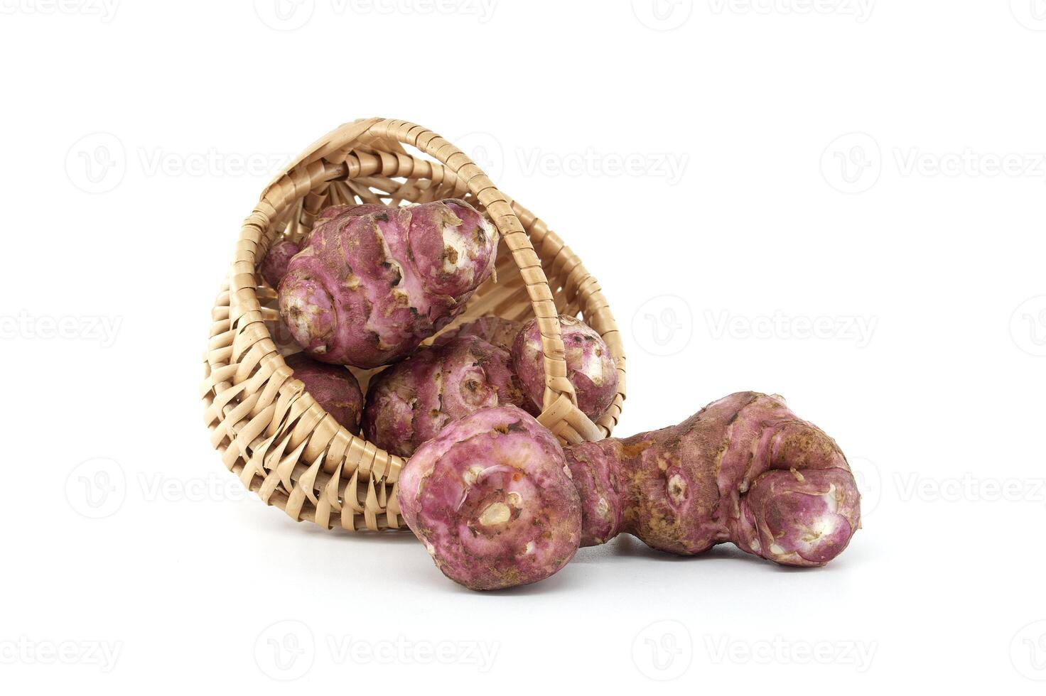 Fresh Jerusalem Artichokes Spilling from Woven Basket on White photo