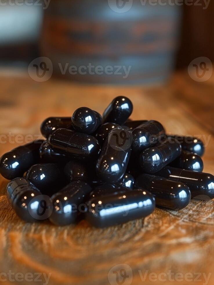 Black capsules arranged neatly on a wooden surface in a warm setting photo