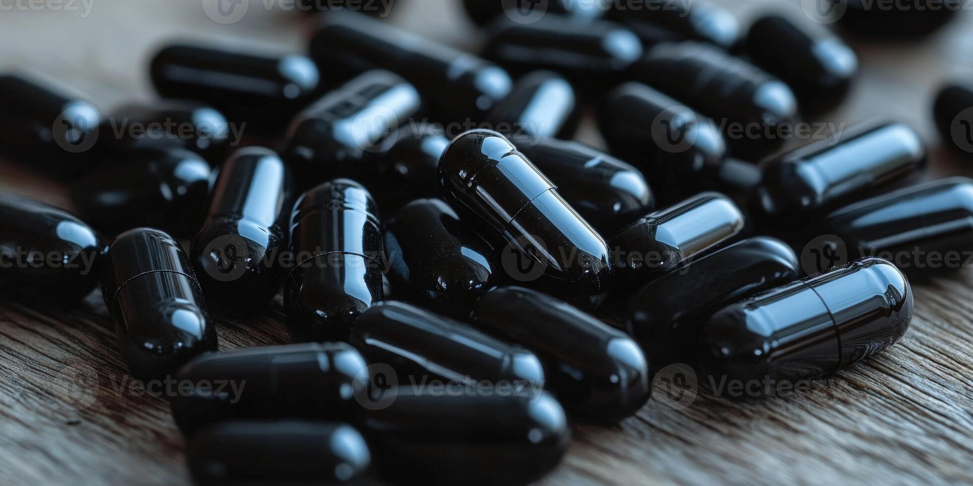 Black capsules scattered on wooden surface in natural light photo