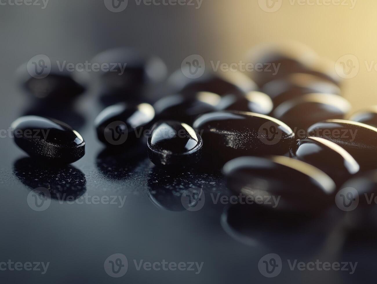 Glossy black seeds scattered on a reflective surface in a bright setting photo