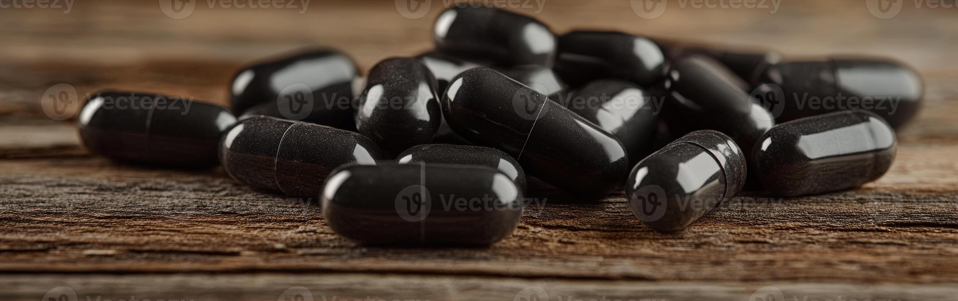Black capsules scattered on a wooden surface during daylight hours photo