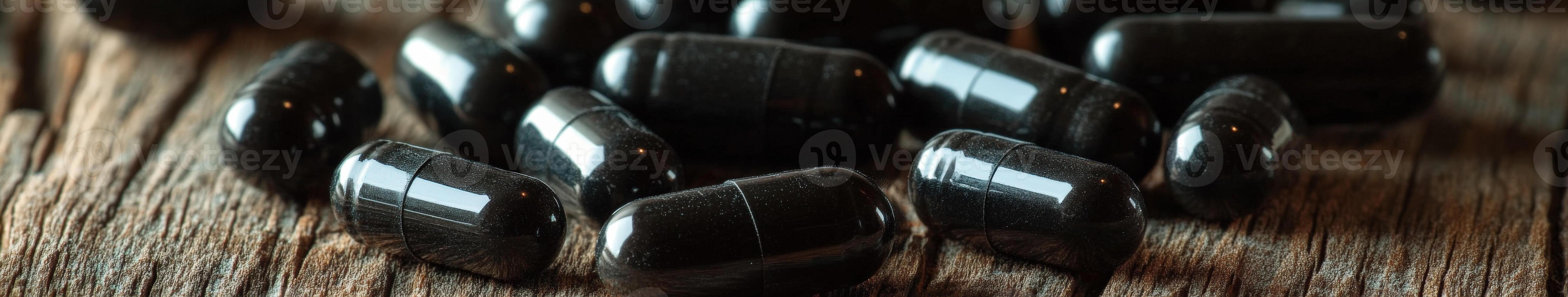 Natural health supplements on wooden surface showcasing black capsules photo