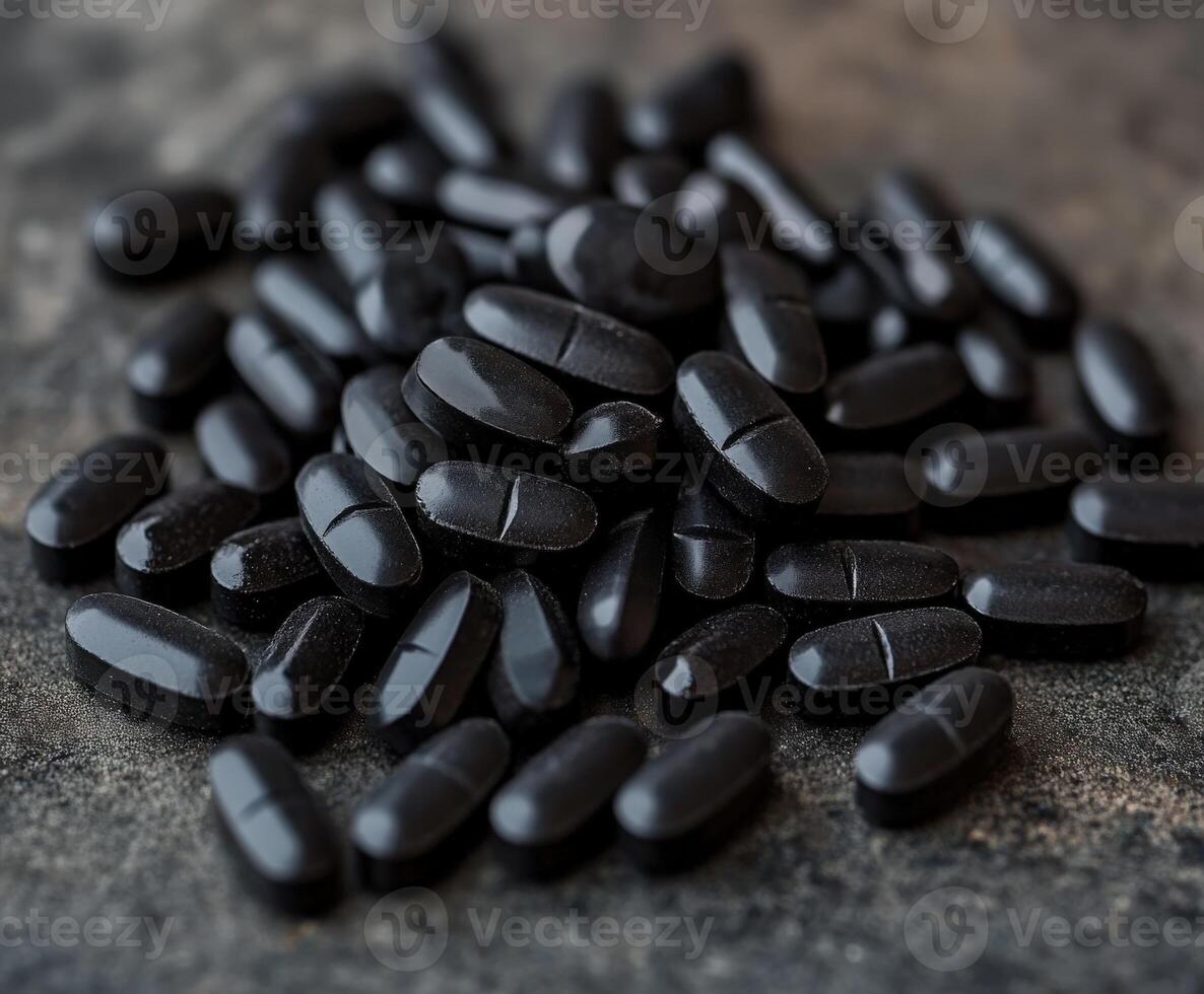 Black dietary supplements arranged on a textured surface for health benefits photo