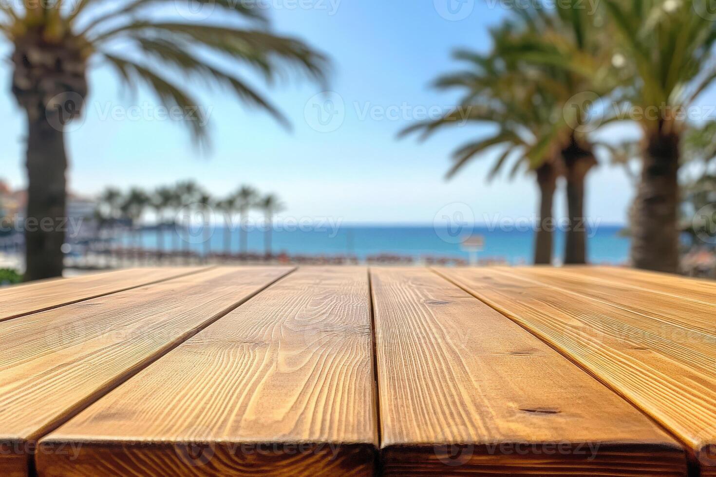 Sunlit wooden table overlooking beach with palm trees by the coast photo