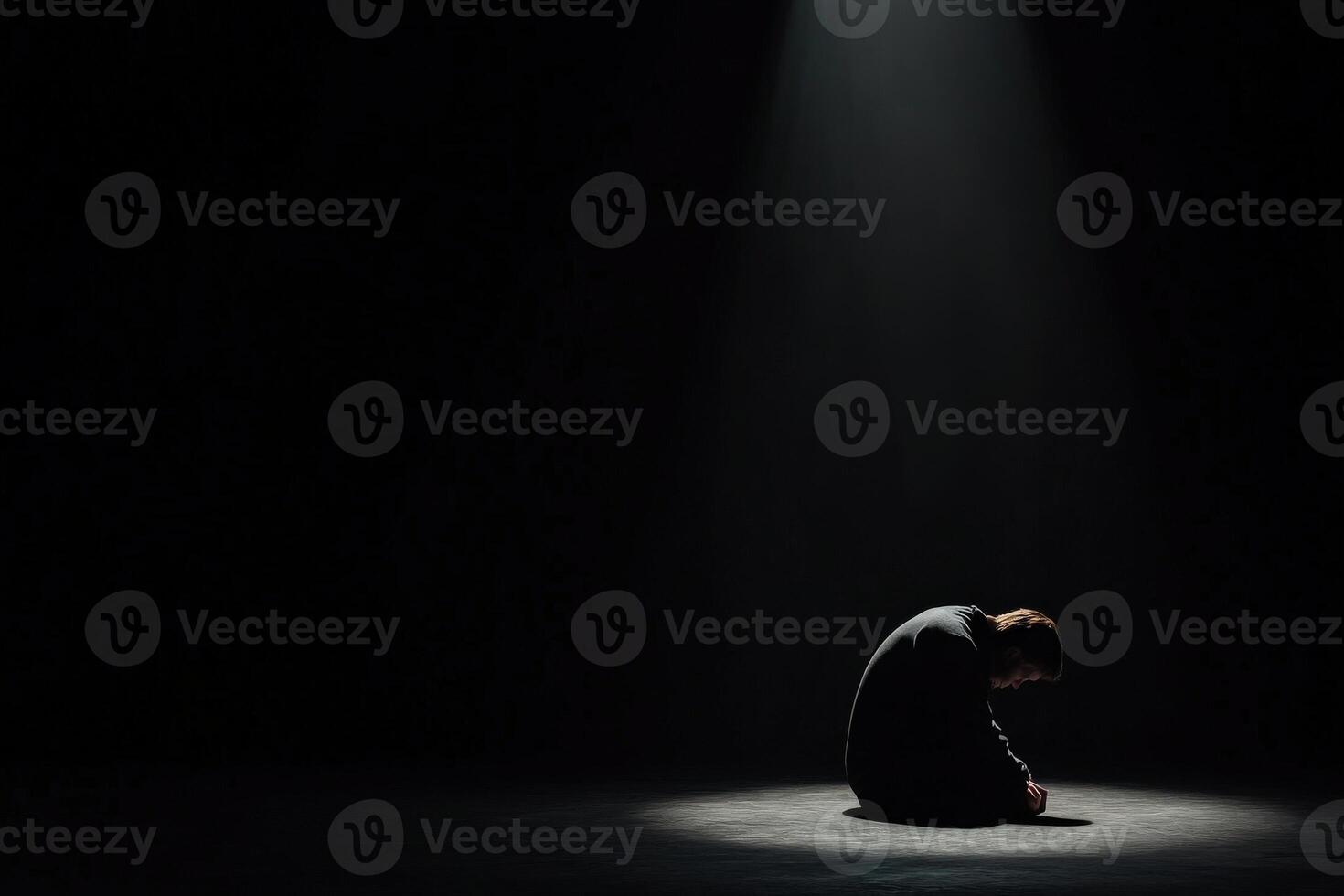 Person sitting alone in dimly lit room during emotional moment of reflection photo