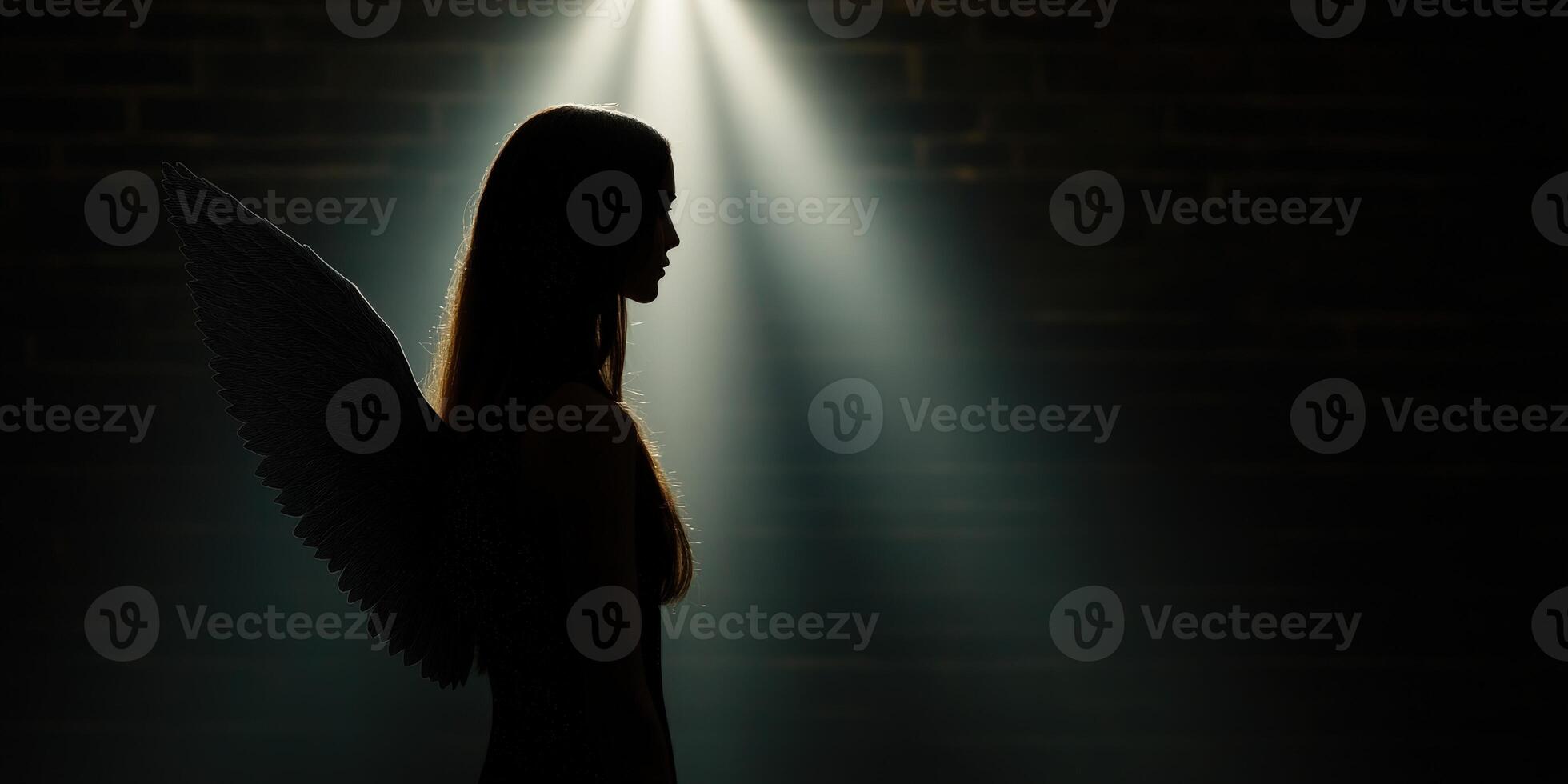 Silhouette of a woman with angel wings illuminated by soft light photo