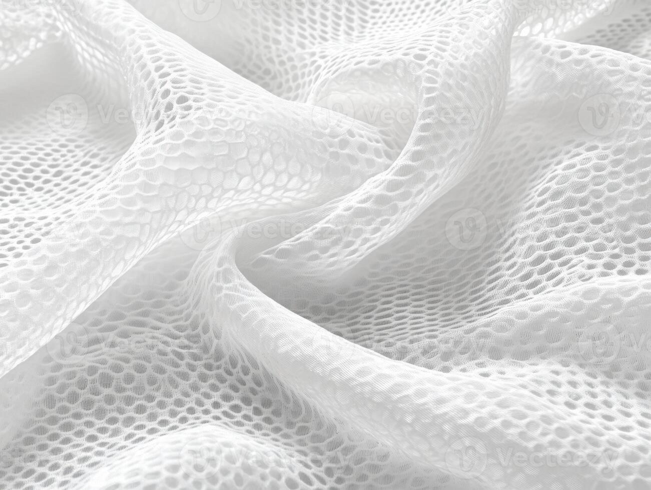 Delicate white mesh fabric displaying intricate patterns under soft lighting photo