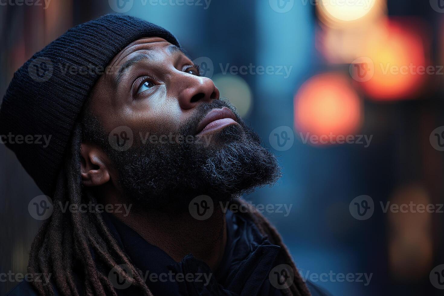 Man gazes upward in urban setting as lights illuminate the background photo