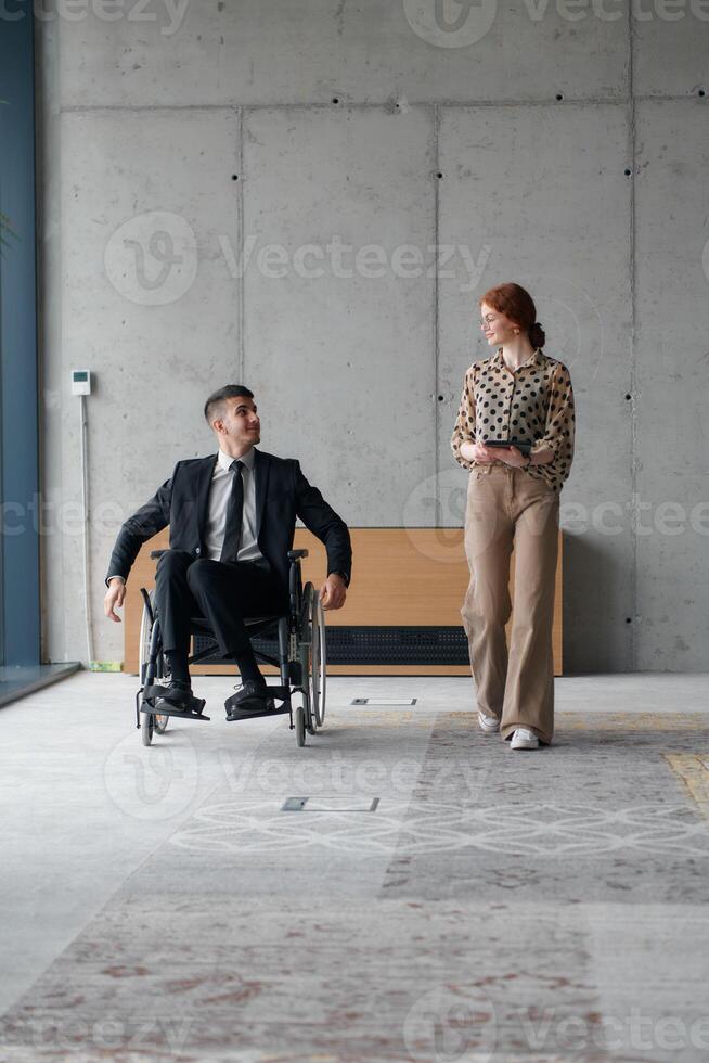 Director in a Wheelchair Navigating the Office While Discussing Business Challenges with a Colleague photo
