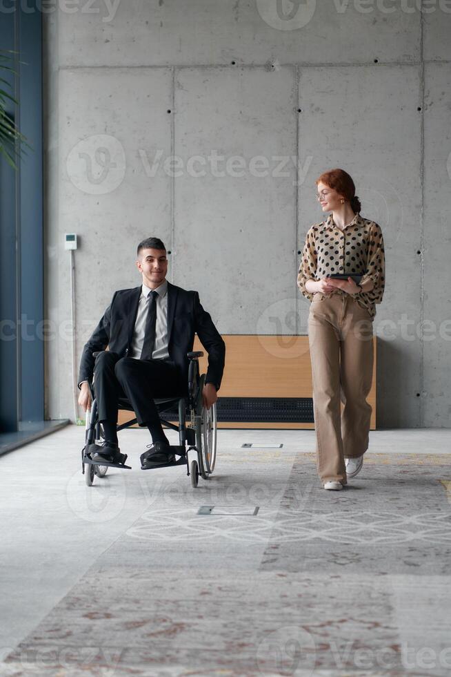 Director in a Wheelchair Navigating the Office While Discussing Business Challenges with a Colleague photo