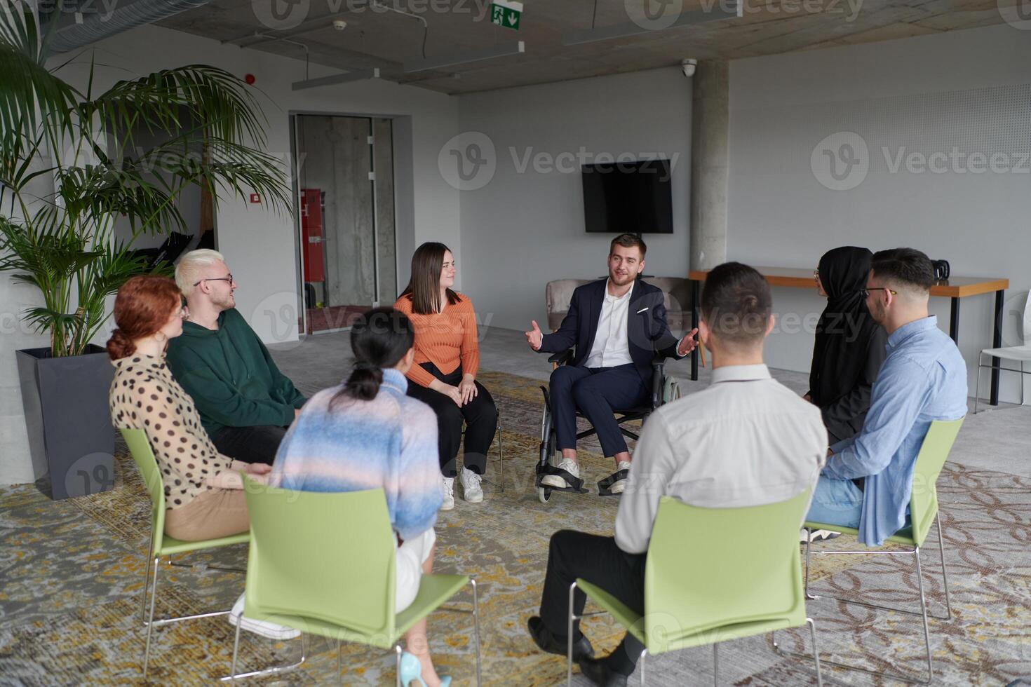 Corporate business team meeting with a manager or coach. Group of happy diverse, multiracial people sitting in a circle photo