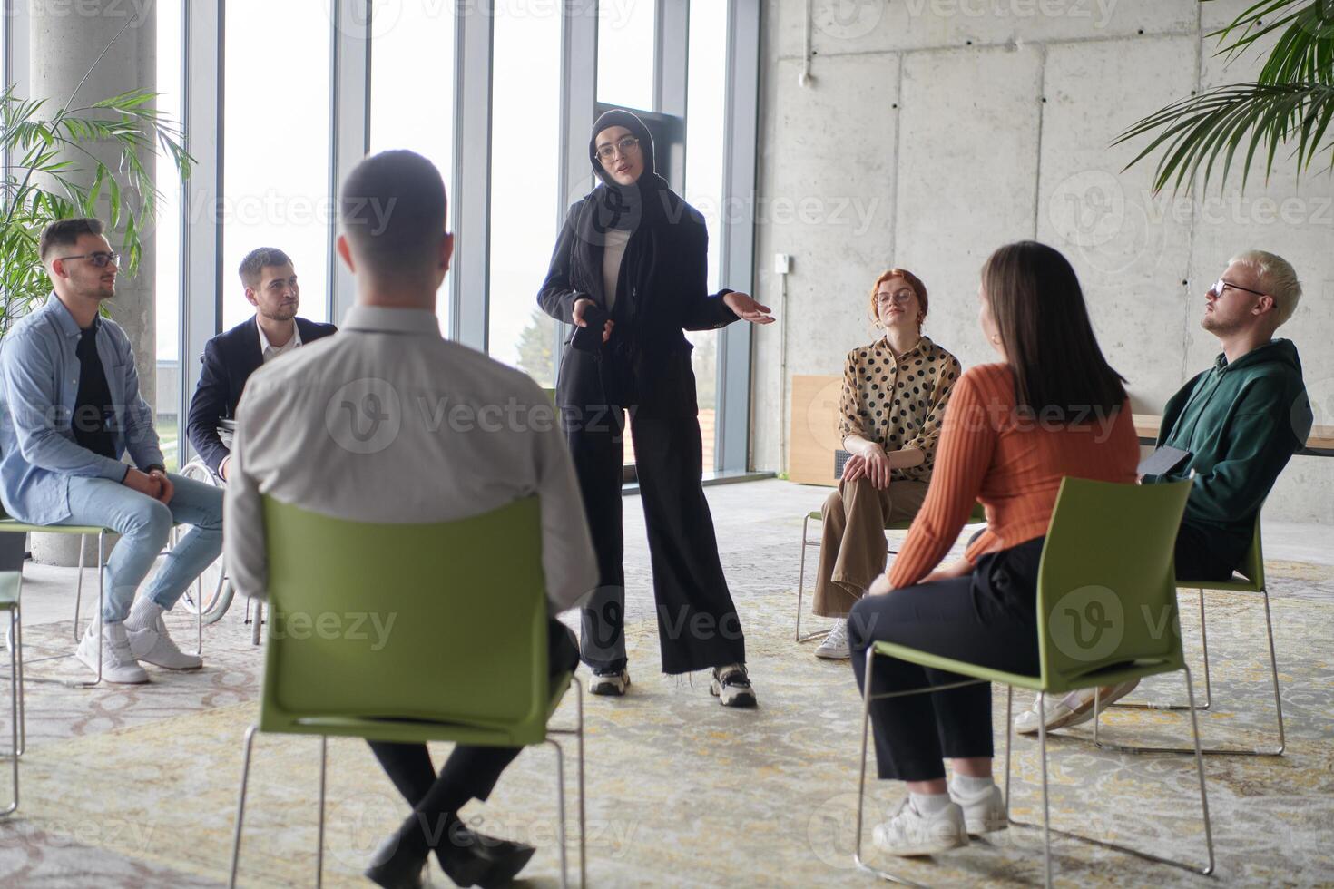Corporate business team meeting with a manager or coach. Group of happy diverse, multiracial people sitting in a circle photo