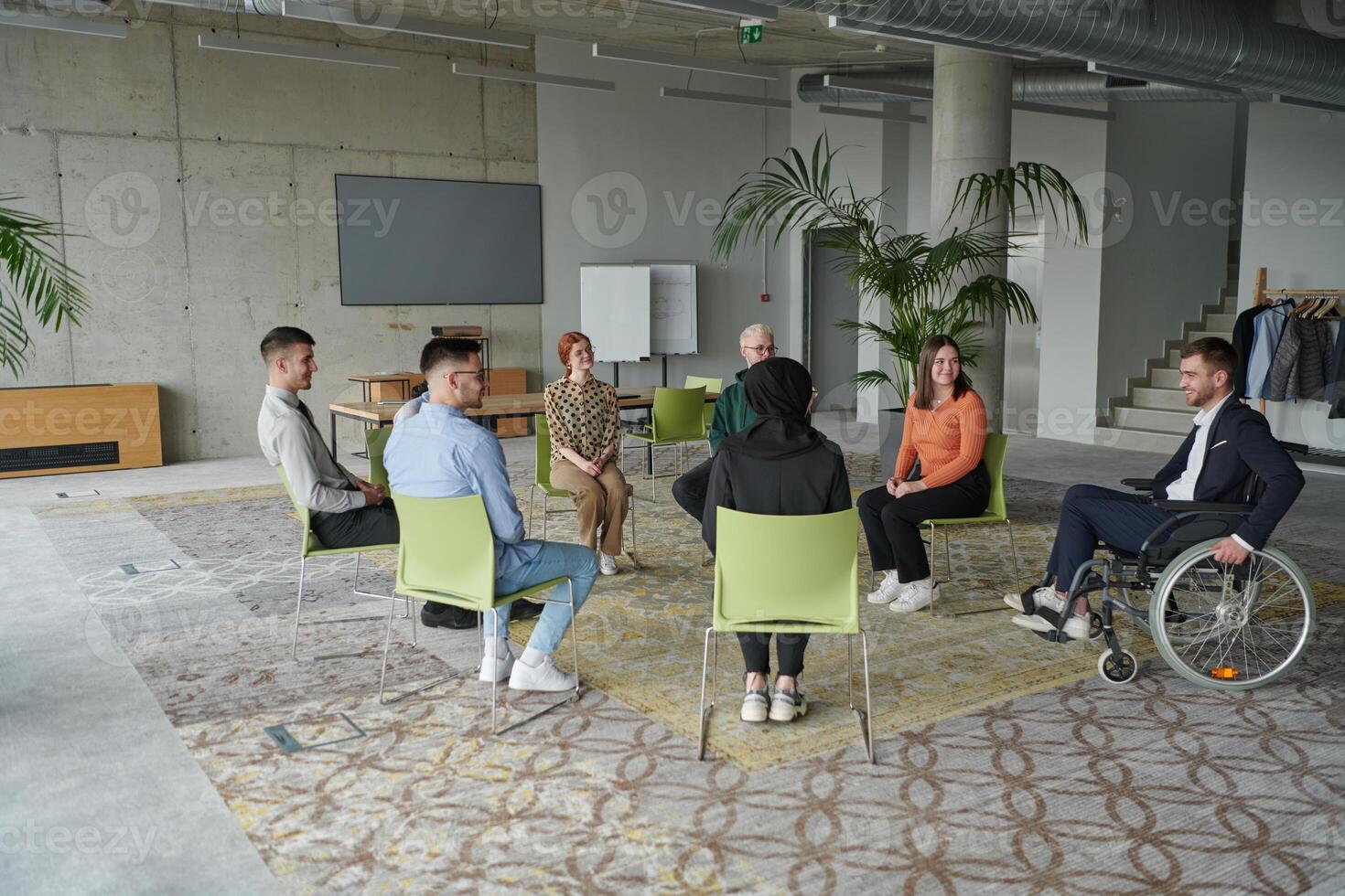 Corporate business team meeting with a manager or coach. Group of happy diverse, multiracial people sitting in a circle photo