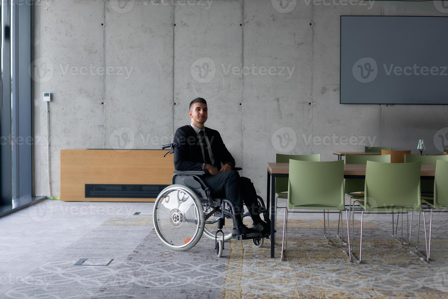 A director in a wheelchair sitting alone in an empty office, deeply reflecting on business strategies and decisions, contemplating the path forward with focused determination. photo