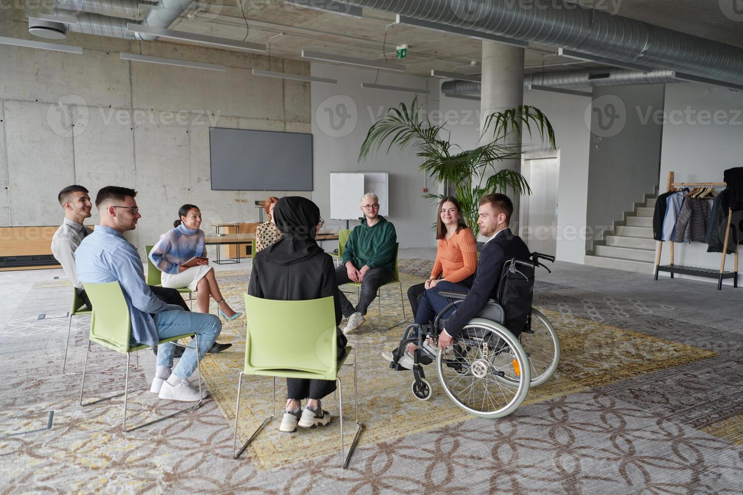 Corporate business team meeting with a manager or coach. Group of happy diverse, multiracial people sitting in a circle photo