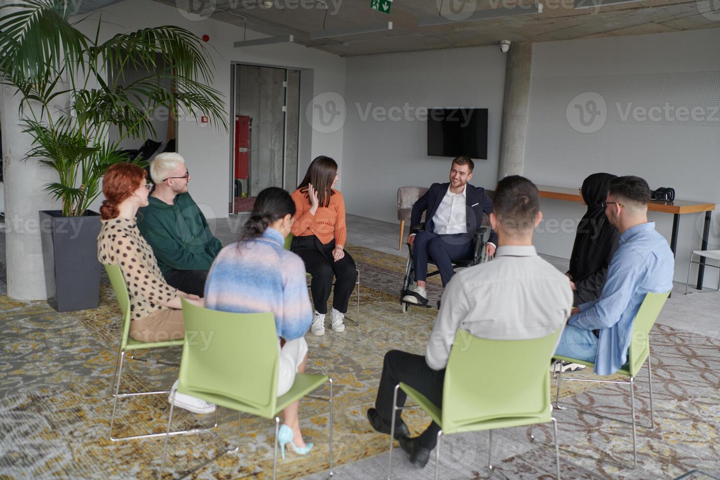 Corporate business team meeting with a manager or coach. Group of happy diverse, multiracial people sitting in a circle photo